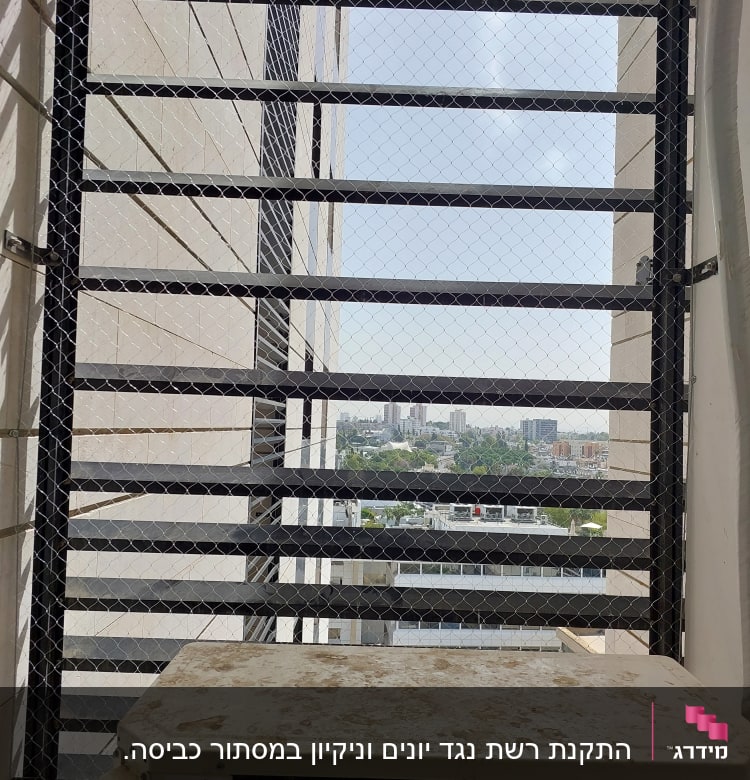 רשת מתכת מותקנת על חלון למניעת כניסת יונים